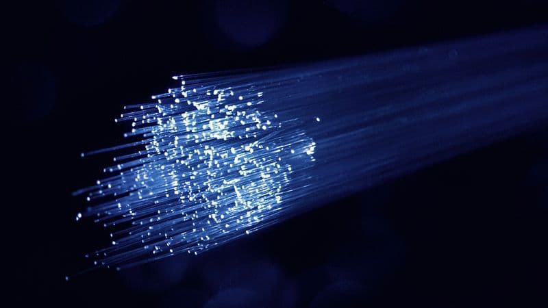 Blue and white fiber optic network cables in a data center transmitting data