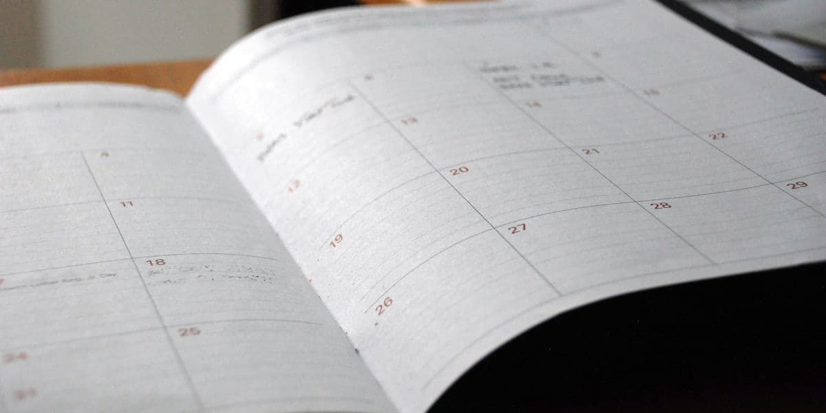 Open monthly planner on a desk illustrating calendar-driven scheduling