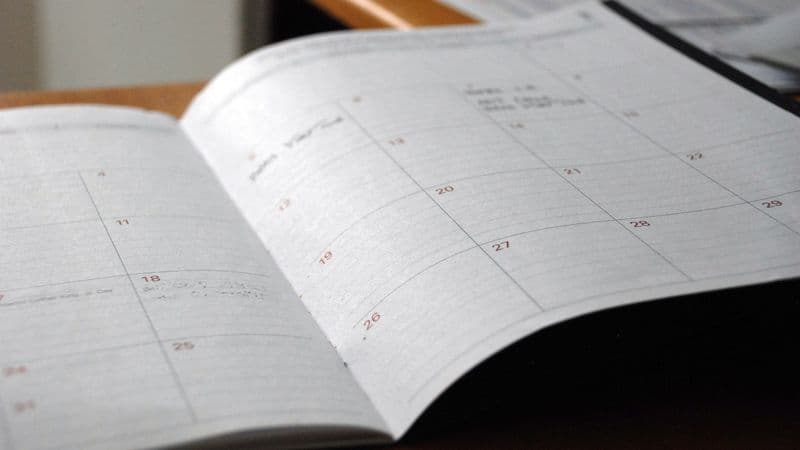 Open monthly planner on a desk illustrating calendar-driven scheduling