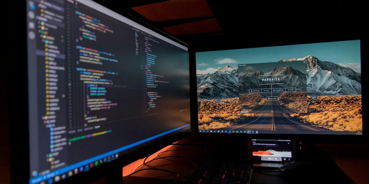 Two desktop monitors displaying analytics charts and code, representing conversion event data pipelines