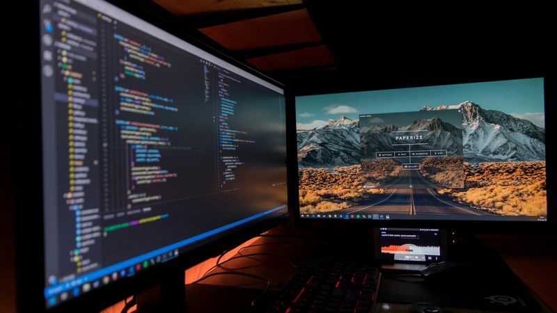 Two desktop monitors displaying analytics charts and code, representing conversion event data pipelines