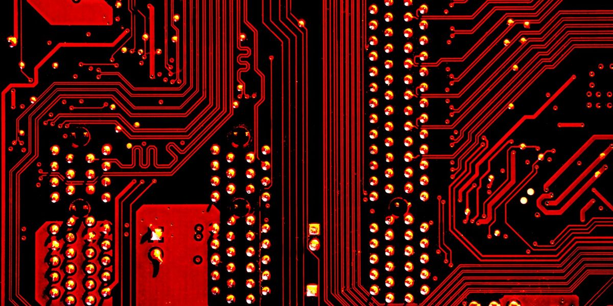 Macro view of red and black circuit board traces and solder points